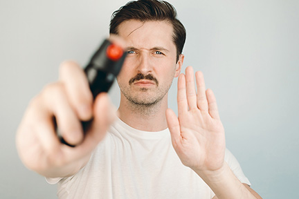 Man holding pepper spray and showing warning gesture