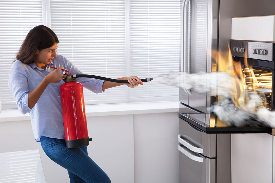Woman putting out kitchen fire