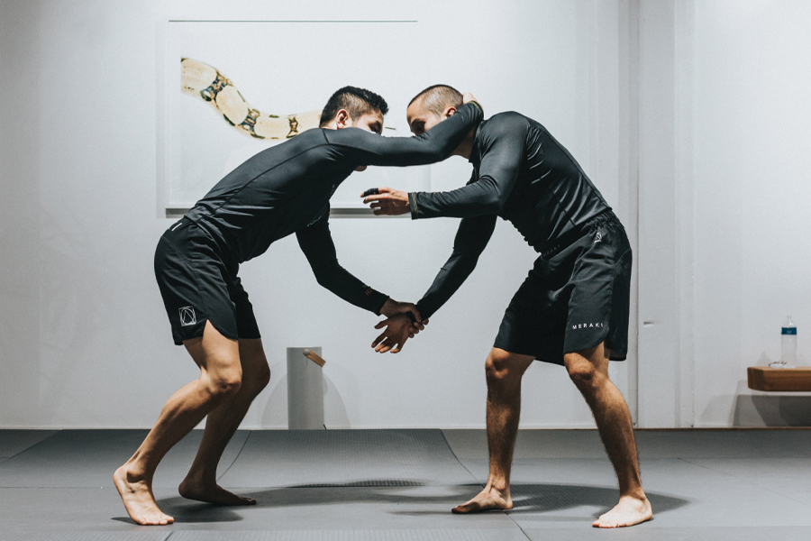 Two men in martial art outfits preparing to spare and practice their martial art skills