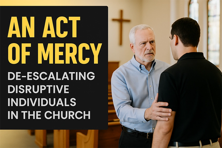 A church safety team member gently speaks with a distressed man inside a sunlit sanctuary. Bold yellow and gray text reads “An Act of Mercy – De-escalating Disruptive Individuals in the Church.