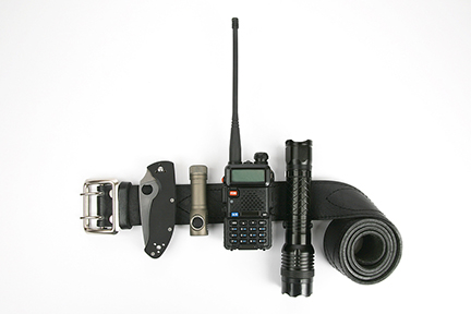 a folding knife, radio transmitter, flashlight, and taser on a black leather belt