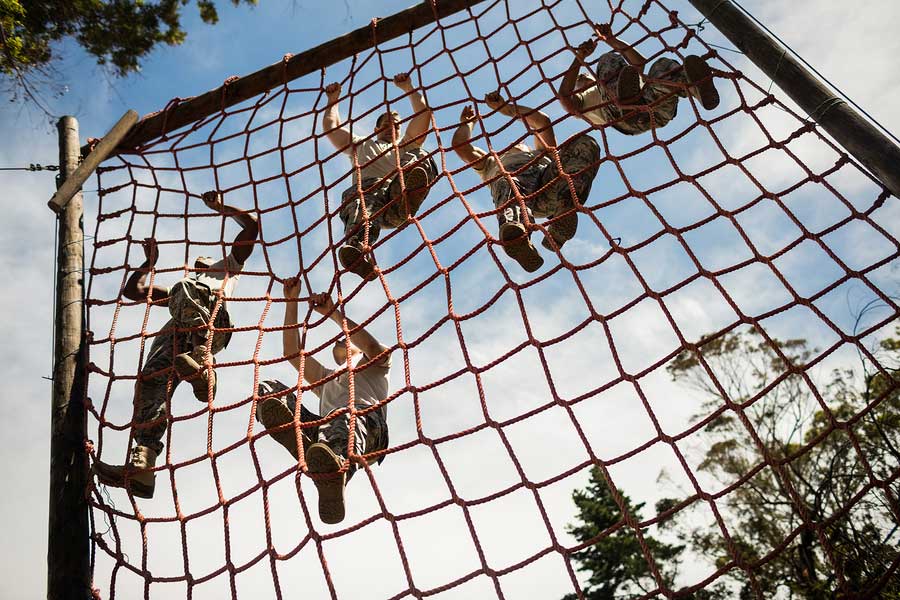 Military men climbing rope course