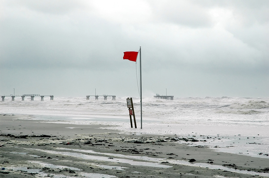 red beach flag warning of an incoming hurricane
