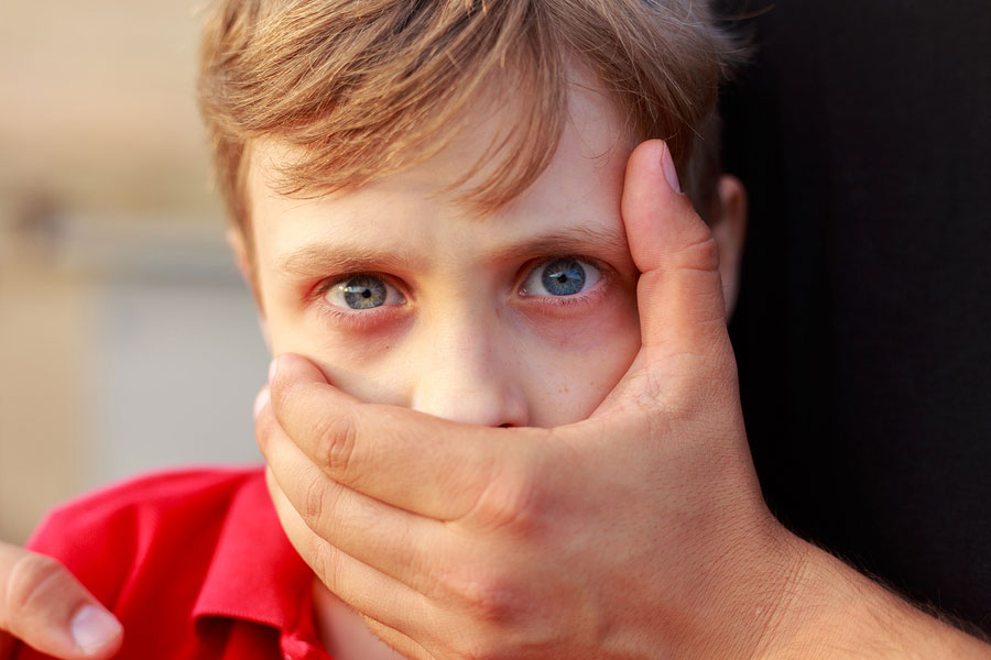 Little boy with mouth covered