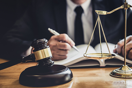 Male lawyer or judge working with contract papers, Law book and wooden gavel on table in courtroom, Justice lawyers at law firm, Law and Legal services concept.