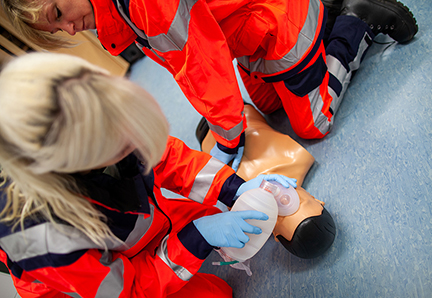 paramedic trains emergency basics on a puppet