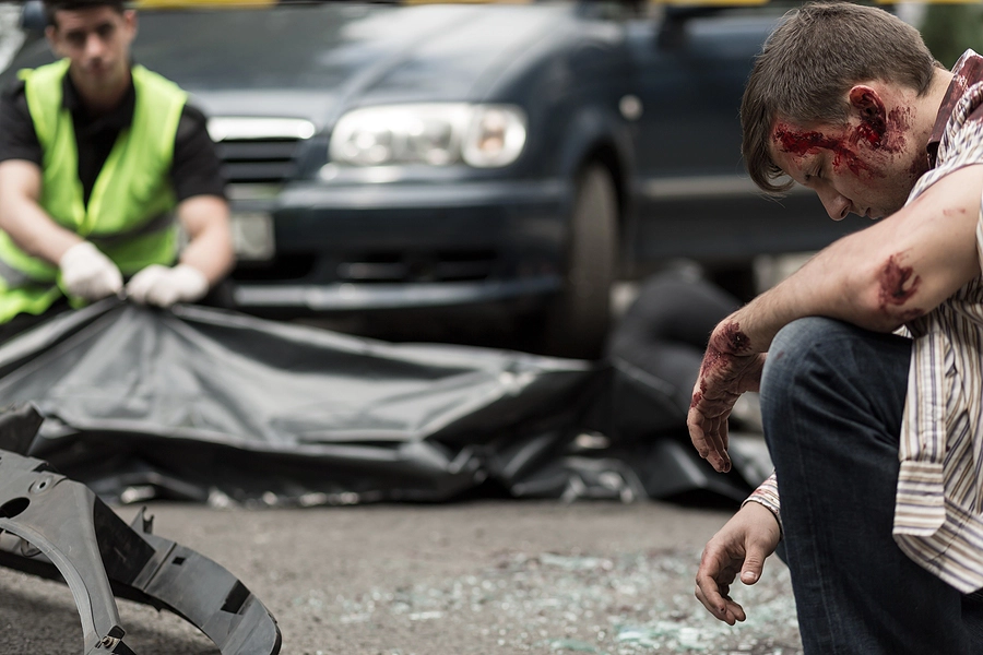 Young bleeding man sitting depressed after car accident