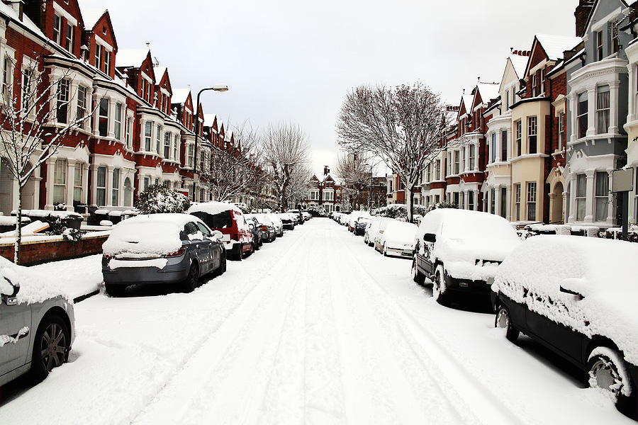 road with snow covered cars and houses