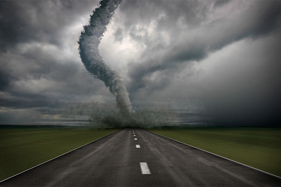 picture of a tornado on a road and a field